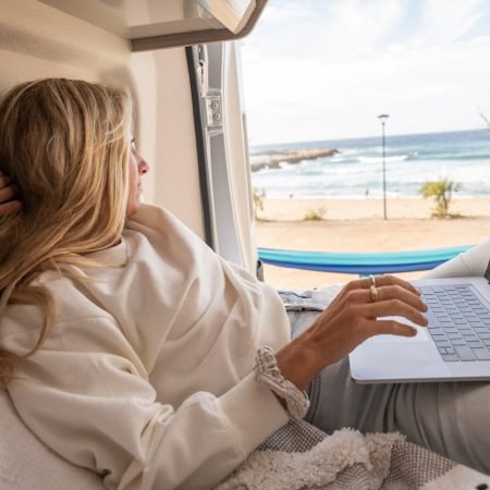 View of woman working on her laptop from a wild camping spot, Sardinia, Italy.
Digital nomad lifestyle
